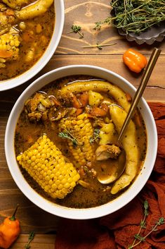 two bowls filled with soup and vegetables on top of a wooden table