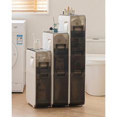 three refrigerators stacked on top of each other in front of a washer and dryer