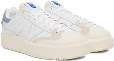 Low-top paneled suede, grained leather, and buffed leather sneakers in tones of white, and blue. · Round rubber cap toe · Lace-up closure · Textile logo patch at foam tongue · Padded collar · Jersey lining · Textured rubber platform midsole · Treaded rubber outsole · Platform: H1.7 in Supplier color: White White Leather New Balance Sneakers, Classic New Balance Leather Skate Shoes, New Balance Leather Skate Shoes With White Sole, New Balance Leather Skate Shoes, New Balance Leather Skate Shoes For Streetwear, New Balance Leather Sneakers With Gum Sole, Cream Leather Skate Shoes For Sports, Sporty Cream Leather Skate Shoes, Urban White Sneakers With Rubber Heel Cap