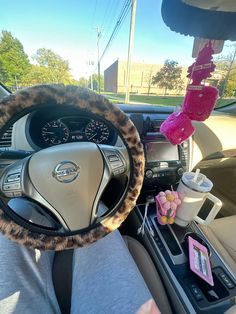 a person is sitting in the driver's seat of a car with a leopard print steering wheel cover