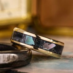 two gold wedding bands sitting next to each other on top of a marble countertop