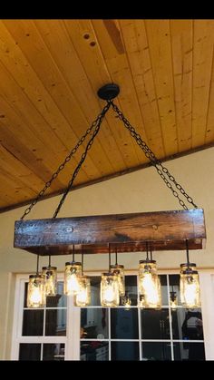 mason jar chandelier hanging from the ceiling in front of a window with windowsill