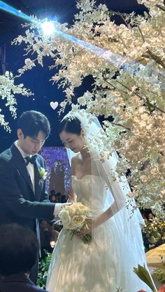 a bride and groom standing in front of an altar