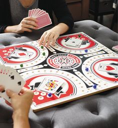 two people playing a card game on a table