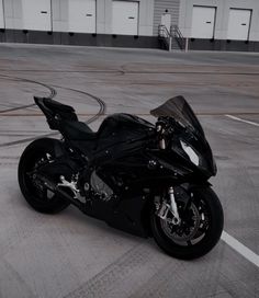 a black motorcycle parked in an empty parking lot