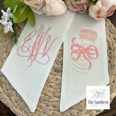 two monogrammed tea towels on a basket with pink flowers and peonies