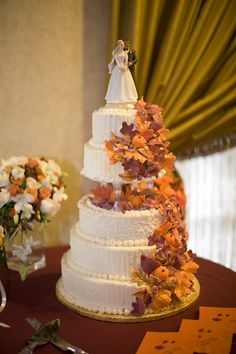 a wedding cake on a table with flowers