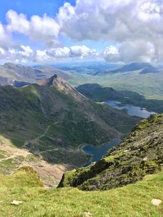 the view from the top of a mountain looking down on a lake and mountains