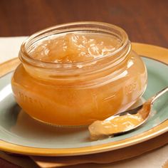 a jar of honey on a plate with a spoon