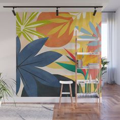 a colorful wall mural with tropical leaves and flowers on it's side, next to a ladder