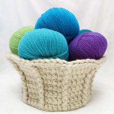 several balls of yarn in a basket on a white background