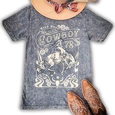 Embrace rugged charm with our Wild West Cowboy Graphic Tee in Gray. This shirt blends timeless style with modern comfort, featuring a relaxed boyfriend fit and a soft mineral wash finish that gives it a vintage, lived-in look. Perfect for casual outings or lounging, its cozy cotton fabric ensures all-day comfort. The graphic print of a classic cowboy adds a touch of Western nostalgia, making it a must-have for those who appreciate both style and ease. Pair it with your favorite jeans or shorts f Spring Stonewashed T-shirt In Washed Black, Vintage Stonewashed Tops For Spring, Vintage Short Sleeve Stonewashed Tops, Vintage Stonewashed Relaxed Fit T-shirt, Vintage Washed T-shirt For Fall, Western Style Washed Cotton Tops, Vintage Stonewashed T-shirt For Spring, Vintage Washed Blue Relaxed Fit Top, Vintage Washed Blue Top With Relaxed Fit