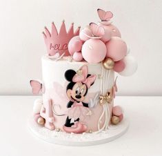 there is a cake decorated with pink and gold decorations on the top, including a minnie mouse