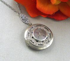 This enchanted locket is 28 inches long. Antique finished round silver locket has beautiful engraved floral patterns on the sides. I have set a antique silver finished Victorian inspired ornament which is embellish with pewter Labyrinth Celtic embellishment. Pendant is finished with silver floral connector, antique silver metal chain, and lobster clasp.. Locket is 32mm in size. It has room for two photos inside! Please note: I DO NOT DO ENGRAVING OR INSERT PICTURES! Thanks for looking:) Mani Bohemian Engraved Round Locket Necklace, Engraved Spiritual Locket Necklace Adjustable, Adjustable Engraved Spiritual Locket Necklace, Bohemian Medallion Locket Necklace, Bohemian Engraved Round Pendant Locket Necklace, Spiritual Nickel-free Locket Necklace, Silver Spiritual Locket Necklace, Bohemian Silver Locket Necklace, Silver Bohemian Engraved Locket Necklace