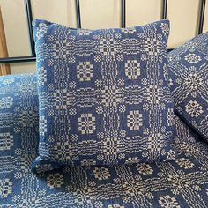 two blue pillows sitting on top of a bed