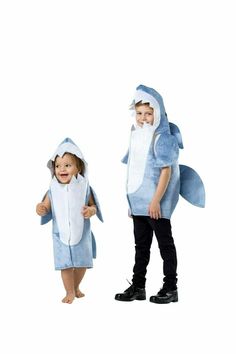 two children in shark costumes standing next to each other