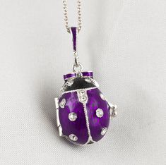 "Bright and festive ladybug locket with heart surprise inside, enameled over solid sterling silver, designed and made in our NJ shop in the tradition of Faberge jewelry. The egg shaped locket ladybug with bright purple wings and a black head, will open to show the red heart inside the locket, steadily fixed in its place. Clear Swarovski crystals are set in the center of the heart, as well as in the dots of the bug and its eyes. The locket is almost 1\"(25 mm) long. You will receive the pendant r Silver Heart-shaped Enamel Jewelry, Elegant Enamel Jewelry Keepsake, Heart-shaped Silver Enamel Jewelry, Enamel Hallmarked Jewelry For Gifts, Hallmarked Enamel Jewelry For Gifts, Purple Enamel Necklace For Gifts, Purple Enamel Necklace For Gift, Silver Enamel Heart Pendant Necklace, Enamel Locket Jewelry For Gifts