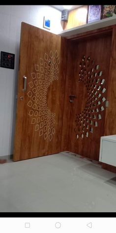 two wooden doors with designs on them in an office building, one is open and the other is closed