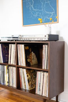 an old record player sits on top of a shelf