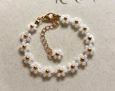 Search Gold Floral Jewelry With Tiny Beads, Gold Flower Jewelry With Tiny Beads, Gold Flower-shaped Jewelry With Tiny Beads, Adjustable Gold Pearl Flower Bracelet, Delicate Gold Beaded Friendship Bracelets, Gold Beaded Bracelet With Flower Charm, Delicate Handmade Gold Beaded Bracelets, Gold Flower Bracelets With Spacer Beads, Bohemian Gold Beaded Bracelet With Flower Charm