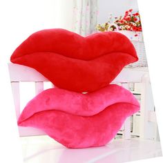 three pillows stacked on top of each other in the shape of lips, one red and one pink