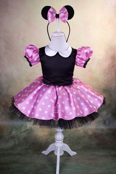 the minnie mouse costume is on top of a mannequin headdress with pink and black polka dots