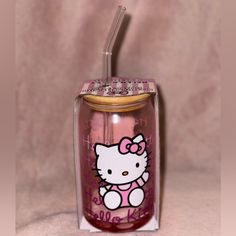 a pink hello kitty tumbler with a straw in it's mouth and lid