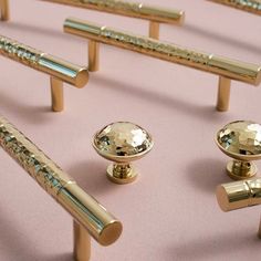 several brass colored handles and knobs on a pink surface