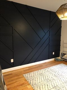 an empty room with dark blue walls and wood flooring on the far wall is a white rug