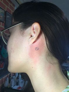 a woman with a small tattoo behind her ear