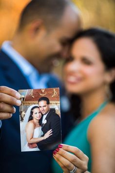 a man and woman holding up a photo