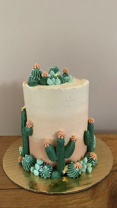 a white cake with green frosting and cactus decorations