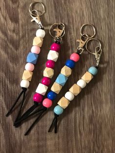 three key chains with different colored beads on them