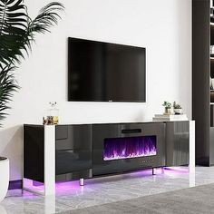 a living room with a large television mounted on the wall next to a fire place