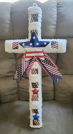 a cross decorated with american flags and ribbons on a couch in front of a sofa