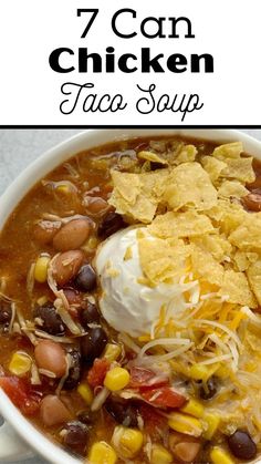 a bowl of chicken taco soup with tortilla chips and sour cream