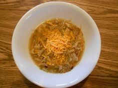 a white bowl filled with food on top of a wooden table