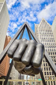 a statue of a fist in the middle of a city