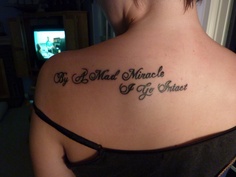 the back of a woman's shoulder with words on it