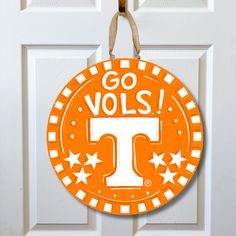 an orange and white door hanger with the letter t on it that says go volls