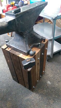 an old hammer and some wooden boxes on the ground in front of a metal table