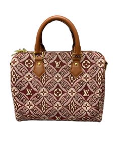 This chic handbag is crafted of red and white Jacquard Since 1854 textile, and brown cowhide leather top handles, trim and an optional shoulder strap . The top opens to a burgundy microfiber interior with a zipper pocket. Condition: like new. Comes with dustbag, lock and two keys. This is a limited edition print and a discontinued color. Product Features: Classic Design: The Speedy Bandouliere 25 features the renowned Monogram canvas, exuding heritage and prestige. Versatility: Equipped with a detachable strap, it can be carried by hand, on the shoulder, or crossbody, adapting to your lifestyle. Spacious Interior: Despite its compact size, the bag boasts a roomy interior to hold all your essentials with ease. Sturdy and Durable: Crafted with LV's signature craftsmanship, this bag ensures l Monogram Canvas Satchel With Leather Handles, Monogram Canvas Satchel With Detachable Double Handle, Designer Burgundy Satchel For Everyday Use, Top Handle Monogram Canvas Bag With Leather Handles, Monogram Canvas Bags With Leather Handles, Monogram Canvas Satchel With Leather Handles Crossbody, Handheld Monogram Canvas Brown Shoulder Bag, Brown Handheld Monogram Canvas Shoulder Bag, Handheld Brown Monogram Canvas Shoulder Bag