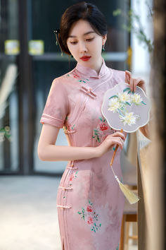 Pink floral cheongsam dress with short sleeves, knotted Chinese buttons, and a mandarin collar. Pink Fitted Dress With Stand Collar, Fitted Pink Dress With Stand Collar, Pink Summer Wedding Cheongsam, Summer Wedding Pink Cheongsam, Elegant Pink Dress With Stand Collar, Pink Short Sleeve Cheongsam For Spring, Pink Short Sleeve Cheongsam For Summer, Pink Fitted Cheongsam With Short Sleeves, Long Pink Feminine Dress