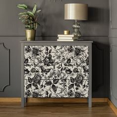 a black and white floral print cabinet next to a lamp