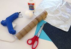 some craft supplies are laying out on a table with glue, scissors and other items