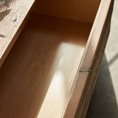 an empty wooden drawer sitting on top of a table