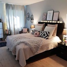 a bedroom with a bed, dressers and pictures hanging on the wall above it