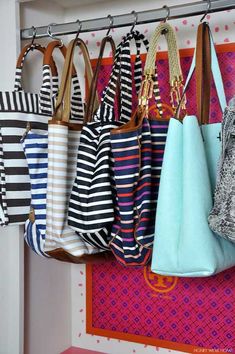 several purses hanging from hooks on a wall