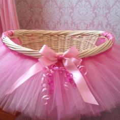 a pink tutule and bow sitting in a basket