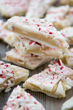 several pieces of white chocolate with red sprinkles on them sitting on a wooden surface